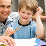 Parent and happy child doing homework.